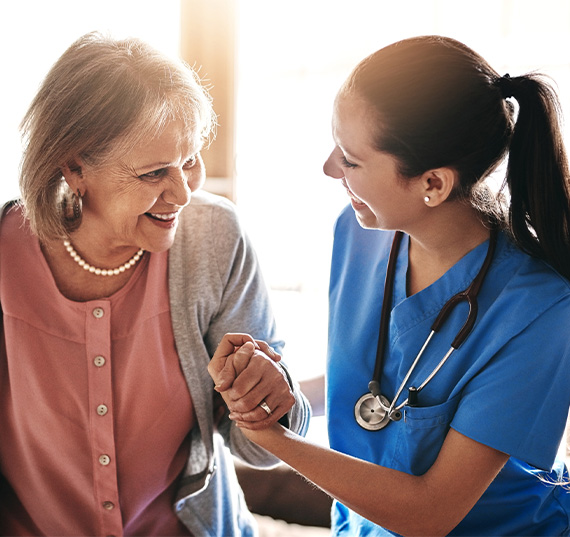 Infirmière aidant une femme âgée souriante